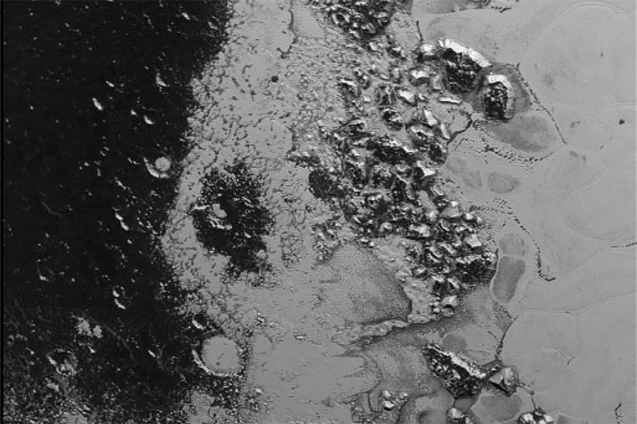 A newly discovered mountain range lies near the southwestern margin of Pluto’s heart-shaped Tombaugh Region, situated between bright, icy plains and dark, heavily-cratered terrain.