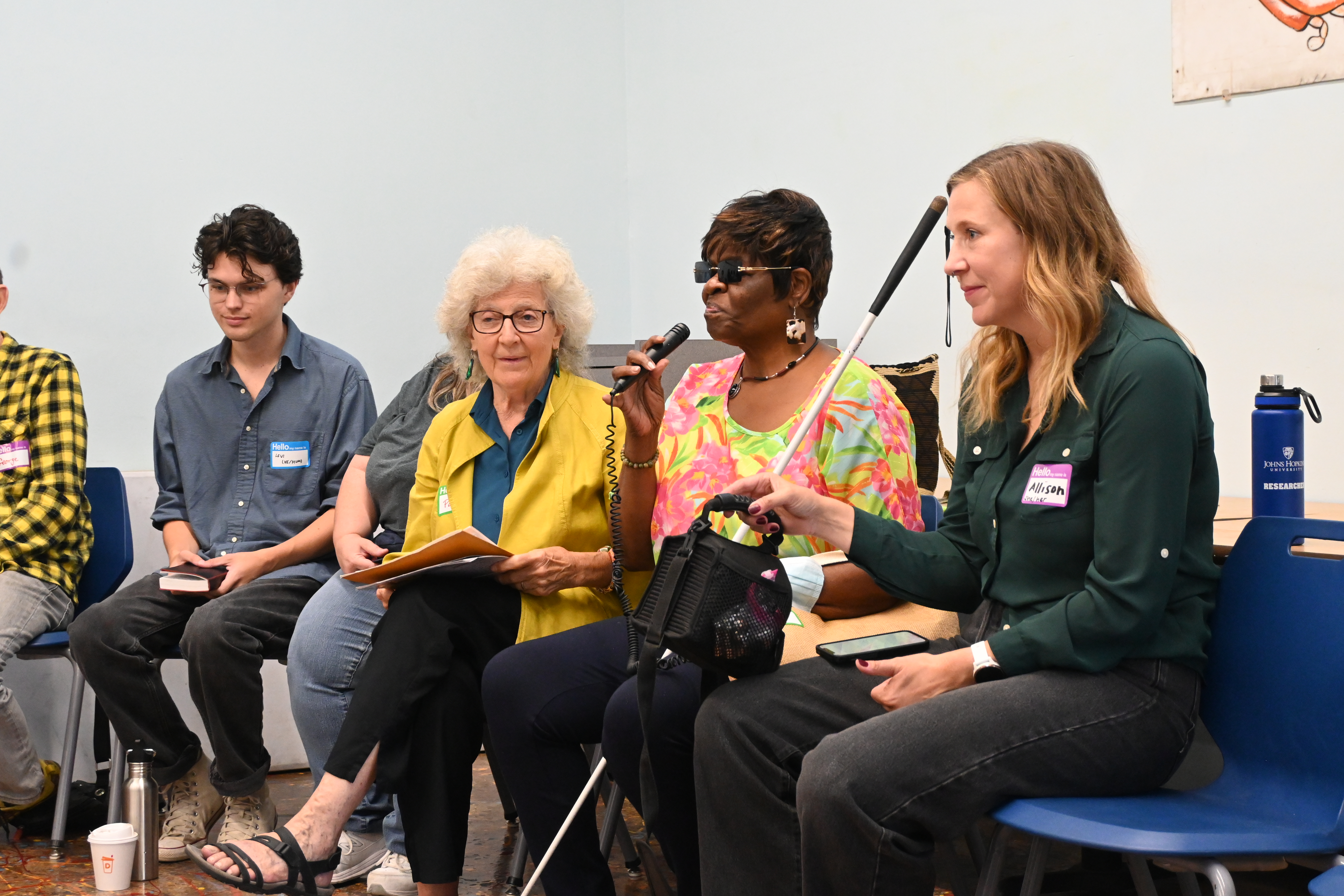 Allison Seyler, far right, holds a portable microphone for a presenter