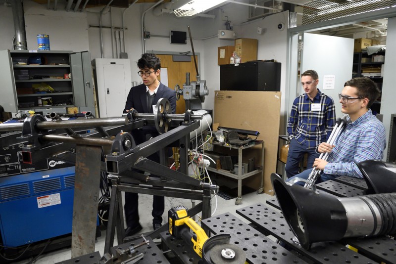 Students in a machine lab demonstrate their device