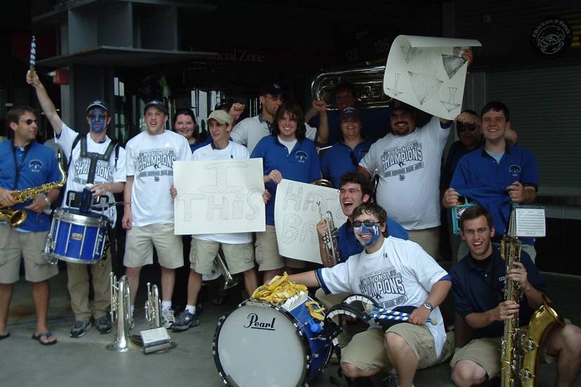 Members of the JHU pep band proudly hold up posters that read 