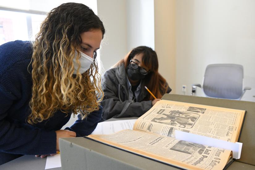 Two students study text in the library's archives.