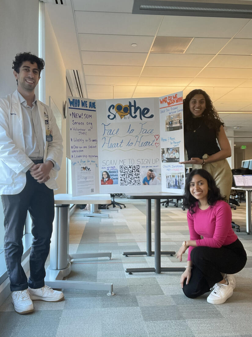 Students smile for the camera with a posterboard that says SOOTHE, Face to Face and Heart to Heart