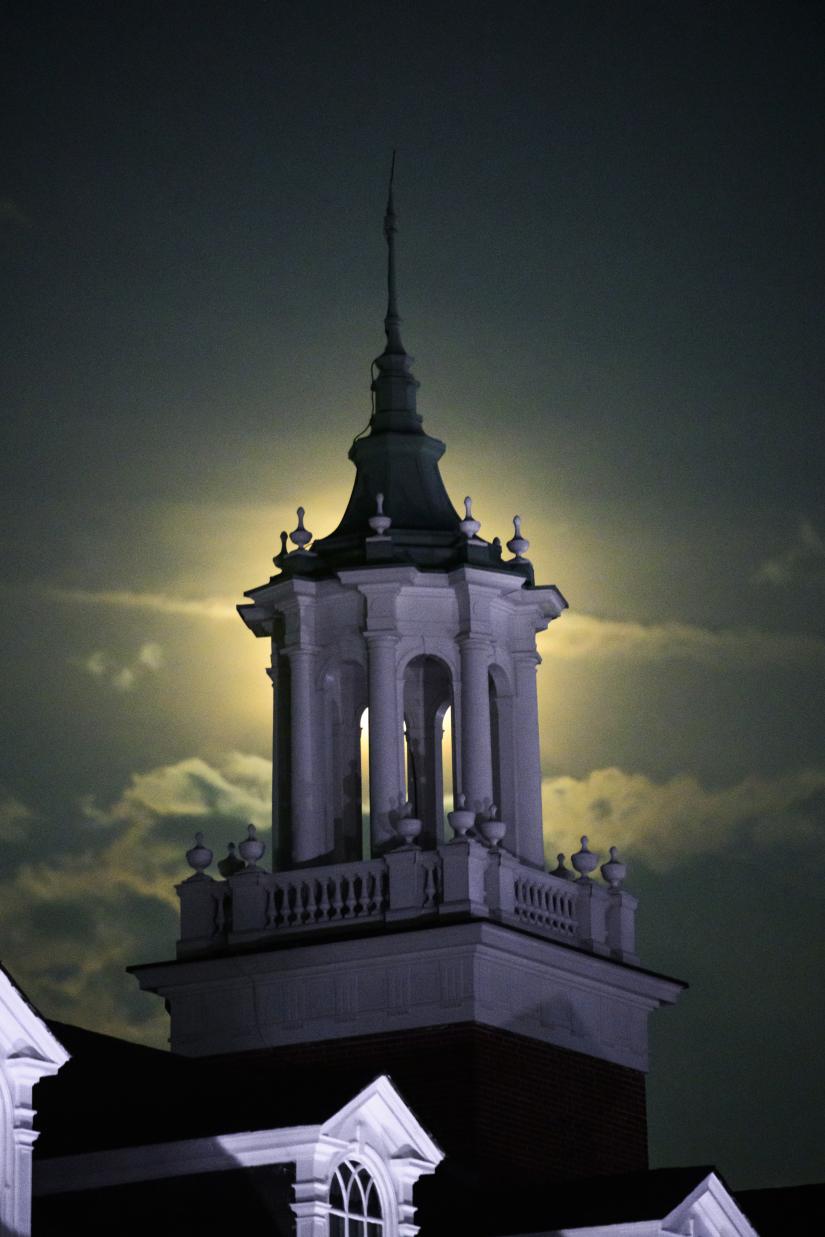 A tower is haloed in moonlight.