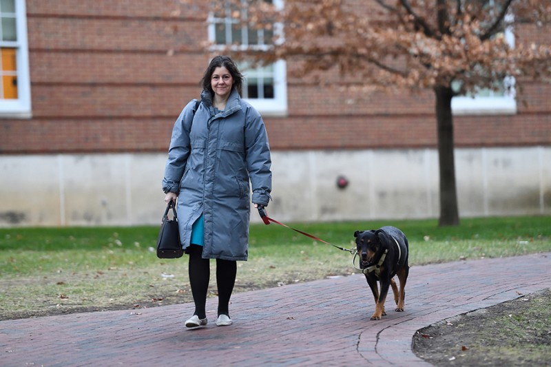 A woman in a puffy coat walks a rottweiler