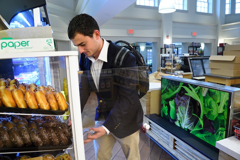 A student picks a baked good from a display case