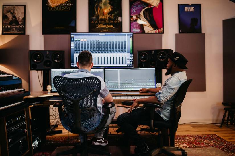 Jacob Yoffee and Roahn Hylton sit and work at a sound board
