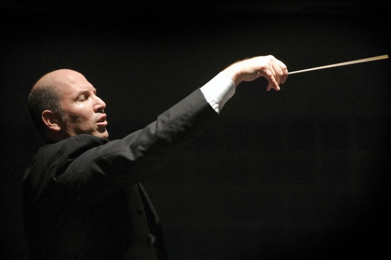 Jed Gaylin holds a baton mid-conducting