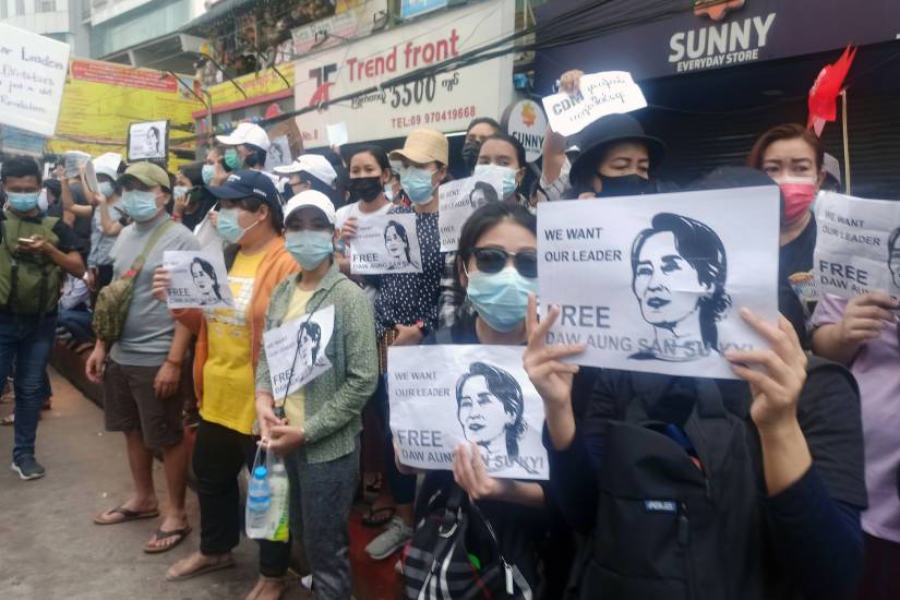 Protesters hold signs calling for release of Aung San Suu Kyi