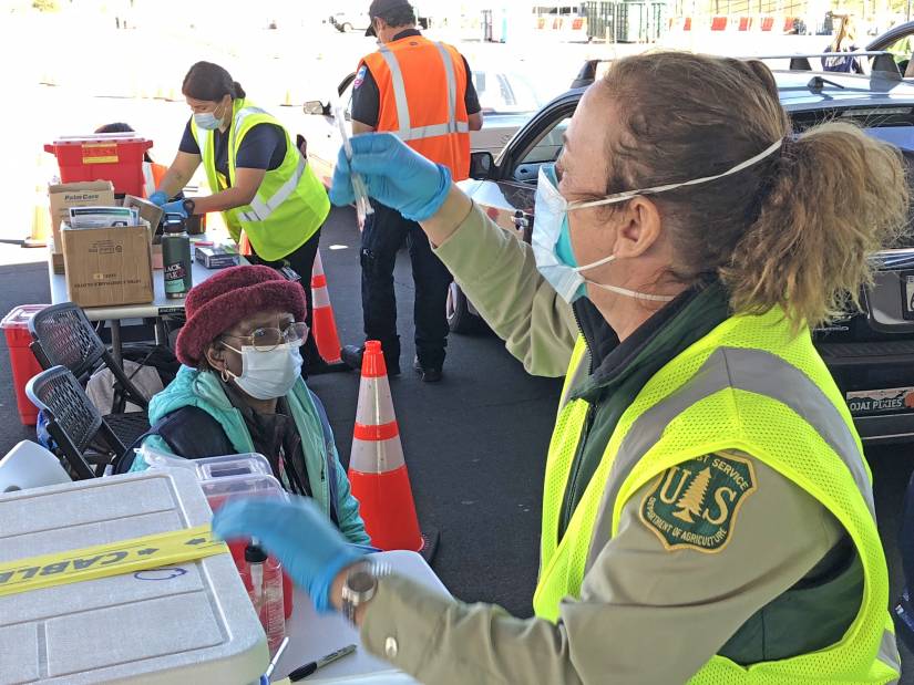 A woman prepares to administer a COVID-19 vaccine