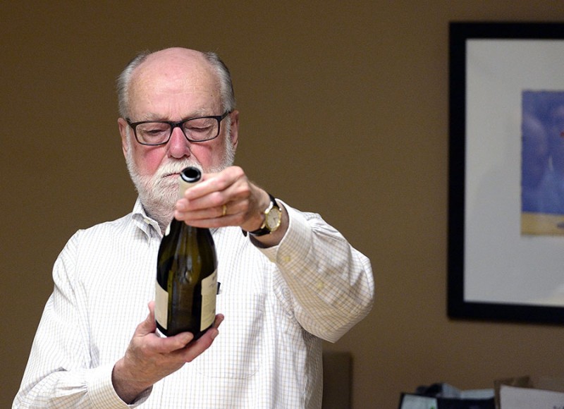 Wine Appreciation instructor looks at the label on a bottle of wine