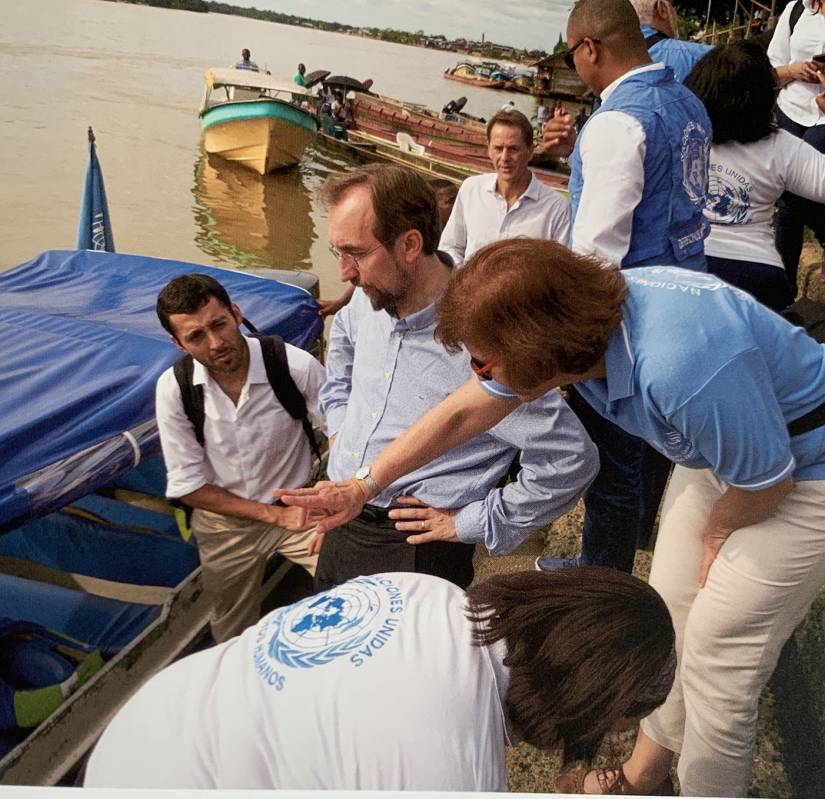 Al Hussein and UN workers stand by a river
