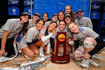 Volleyball team poses with the NCAA championship trophy