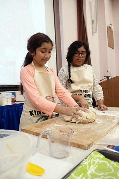 Little girls help bake bread