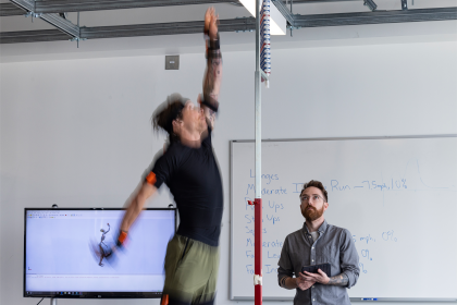 A scientist records the vertical leap of a person wearing biometric sensors