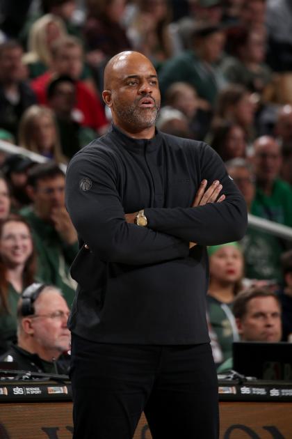 Wes Unseld Jr. stands courtside with his arms crossed