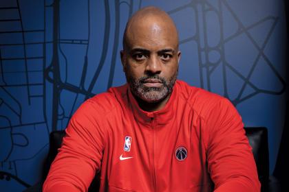 Wes Unseld Jr. in a red half-zip sweatshirt against a blue background