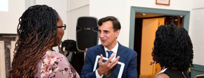 Photograph of two Black women talking with Ron Daniels, a white man