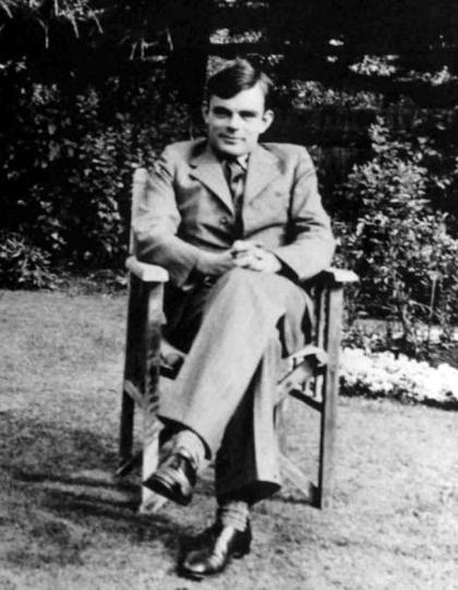 Alan Turing seated in a chair