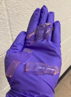 Gelbots sit in the palm of a purple-gloved hand