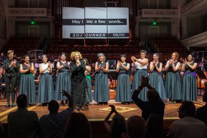 Julia Wolfe clasps her hands as an audience applauds her