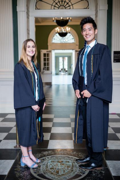 Two scholar athletes step on the JHU seal in Gilman Hall at the 2023 special ceremony for athletes