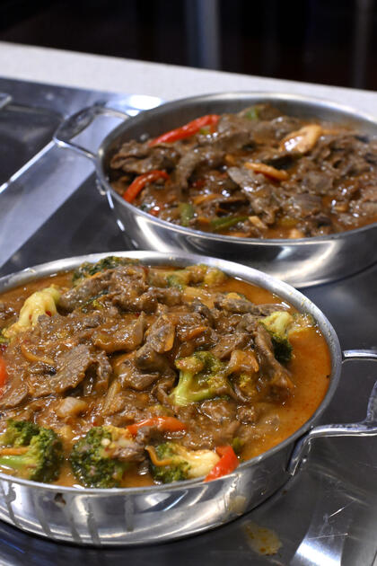 Two pans of hot stir-fry toppings.