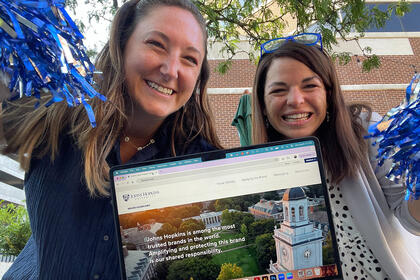  Beth Fritzinger and Abby Jackson hold a laptop showing the website