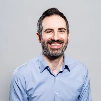 A professional headshot of Nick Cueno