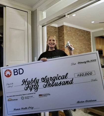 Casey Grage holds a novelty check for $50,000 awarded to her for her product, Hubly Surgical