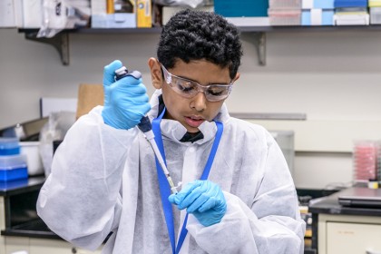 A seventh-grader practices using a pipette in the JHU Wet Lab