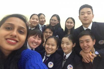 A woman takes a selfie with a group of students