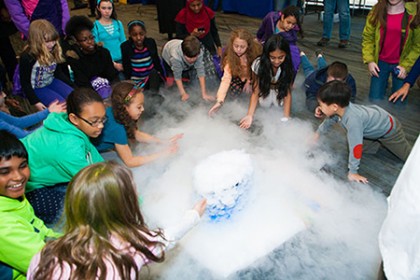 Girls gather around dry ice and fog at APL's Girl Power Event