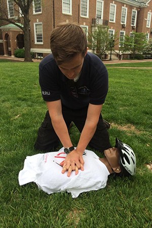 A student practices CPR maneuvers on a manikin