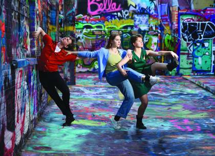 Dancers in a colorful graffitied room