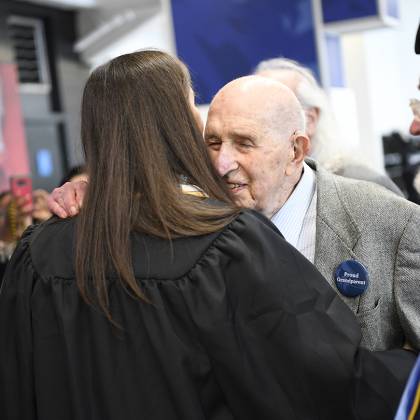 Seymour Baron hugs his granddaughter with a 