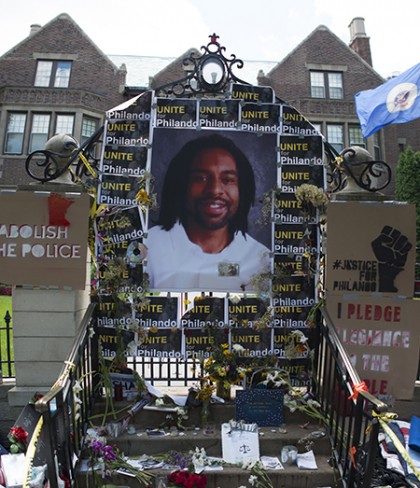 Picture of Philando Castile surrounded by flowers, protest signs
