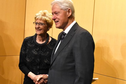 Ellen MacKenzie (left), dean of the Bloomberg School of Public Health, shakes hands with former President Bill Clinton