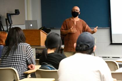 An instructor speaks with students in a classroom