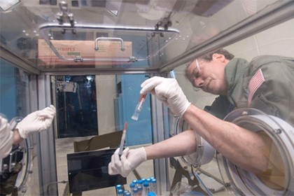 Andy Feinberg works with pipette aboard NASA's zero-gravity aircraft