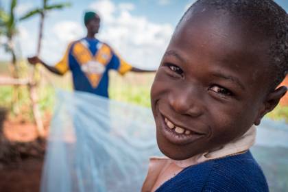 Alex and his father open a mosquito bed net that he received at school in Tanzania. 