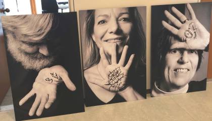 Three sepia-toned photograph portraits of two women and a man who each have an image drawn on their hand in black ink