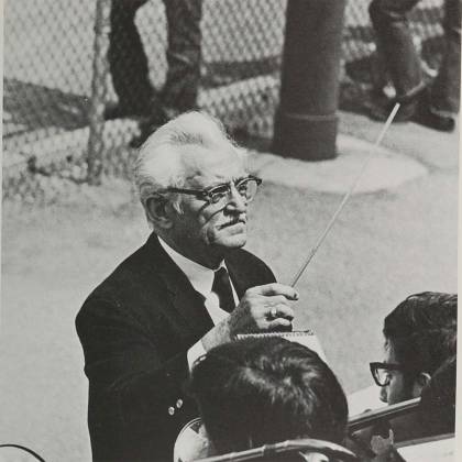 Closeup of conductor Conrad “Gebby” Gebelein holding a baton