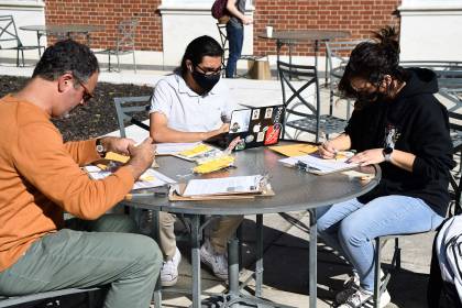 Alessandro Angelini, Mufasa Cruz Moreno, and Valerie Leal work on handwriting toe tags for Hostile Terrain 94
