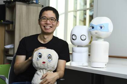 Chien-Ming Huang with the robots in his laboratory