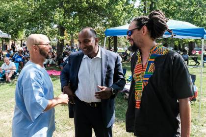 Three men speak at a festival