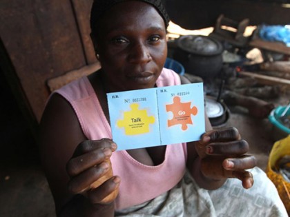 A woman holds two cards, one labeled 