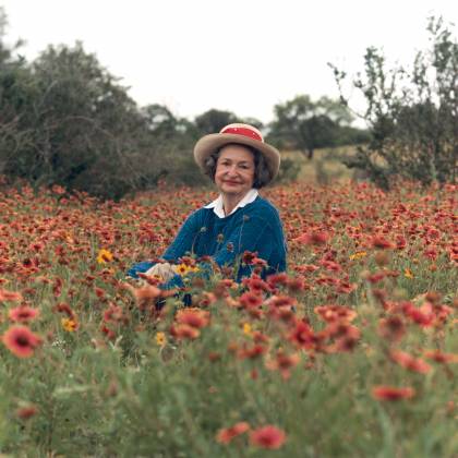 Lady Bird Johnson sits among a field of flowers