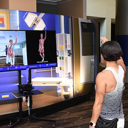 A woman views her musculoskeletal system on an interactive screen