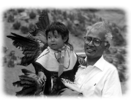 Black and white photo of Mathuram Santosham holding a young Indigenous boy