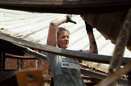 A volunteer with Team Rubicon helps sort through rubble